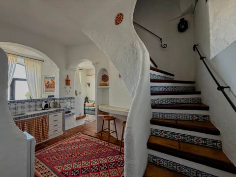 The tiled staircase and arched kitchen of the Molino Escamillos apartment at Molino del Carmen